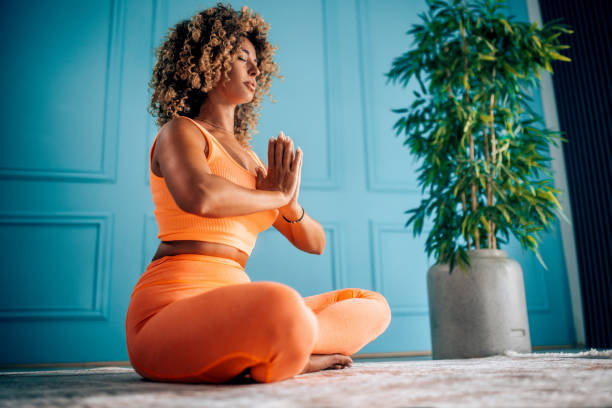 Woman in orange workout clothes meditating