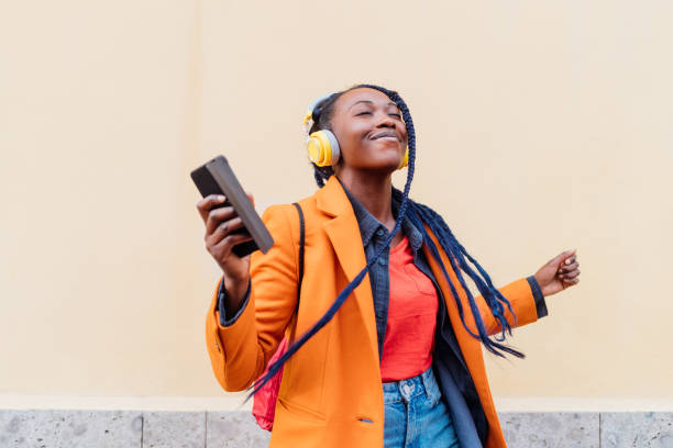 Woman listening to music and vibing, wearing orange
