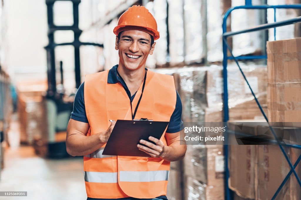 Man smiling wearing safety vest and hard hat
